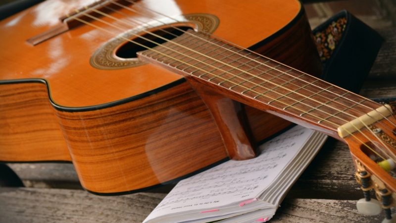 Brown Acoustic Guitar on White Music Note Book